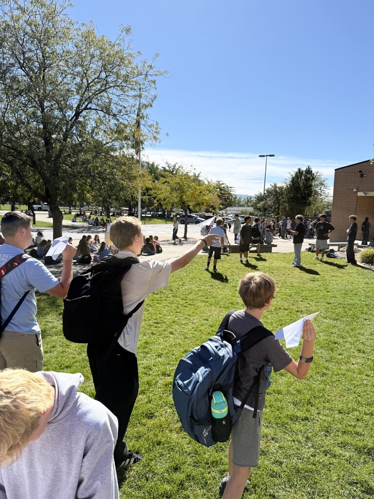 Students flying paper airplanes.