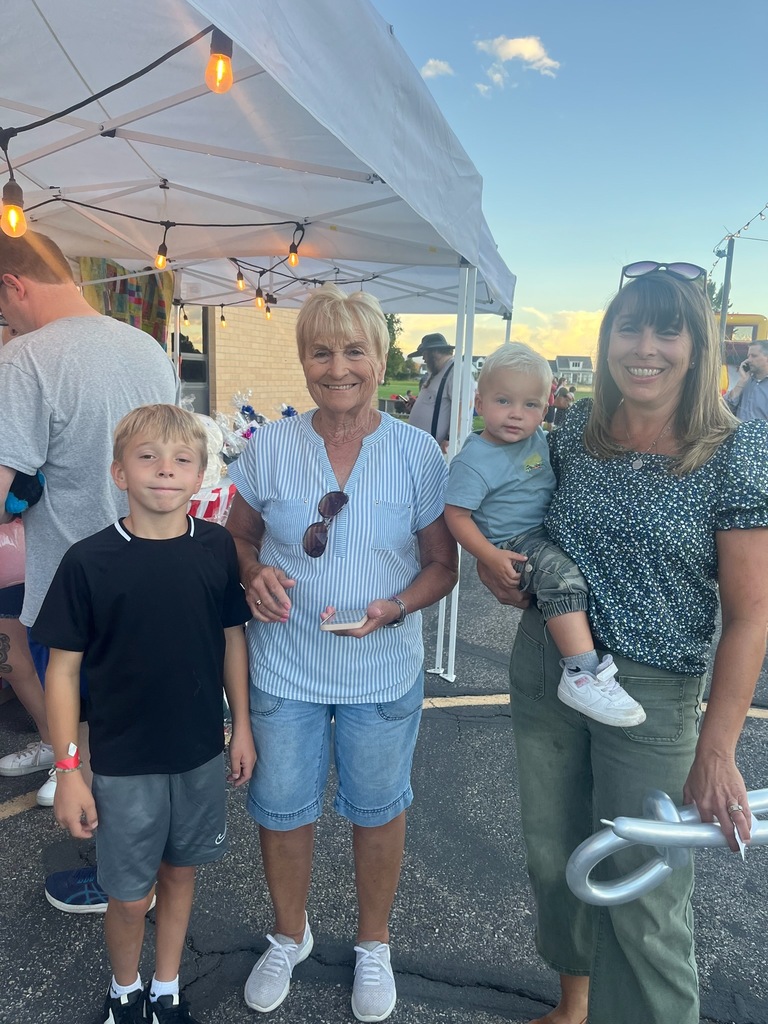A child at his school carnival poses with his grandmother and mother.