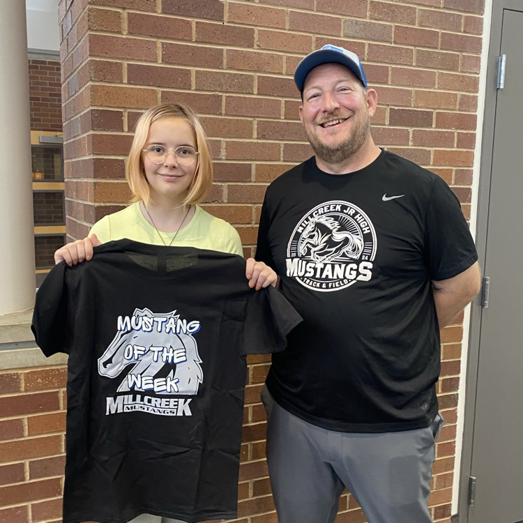 Principal Hansen and student showing her Mustang of the Week shirt