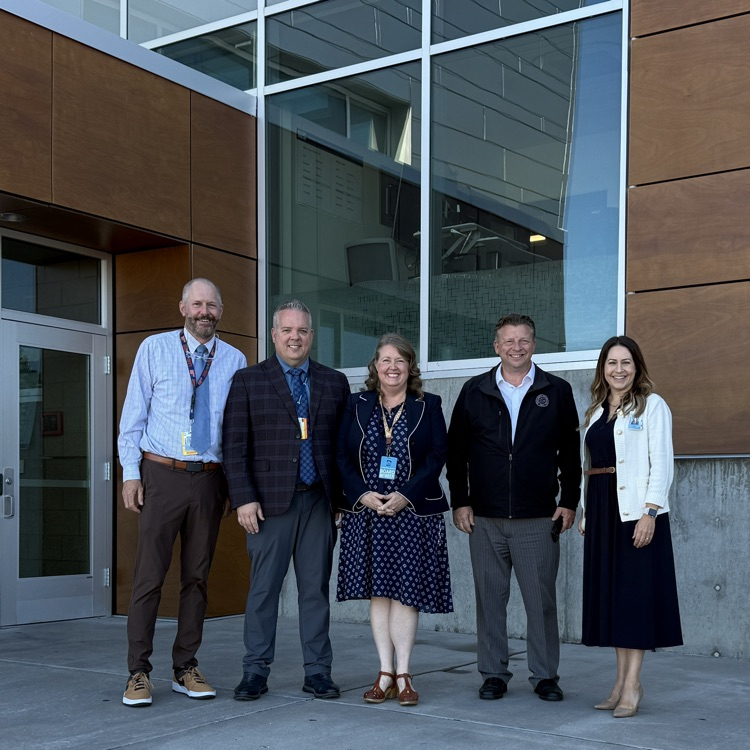 5 people stand in front of a school. left to right - Jason Smith, Dr Dan Linford, Alisa Mercer, Senator Todd Weiler, Joani Stevens