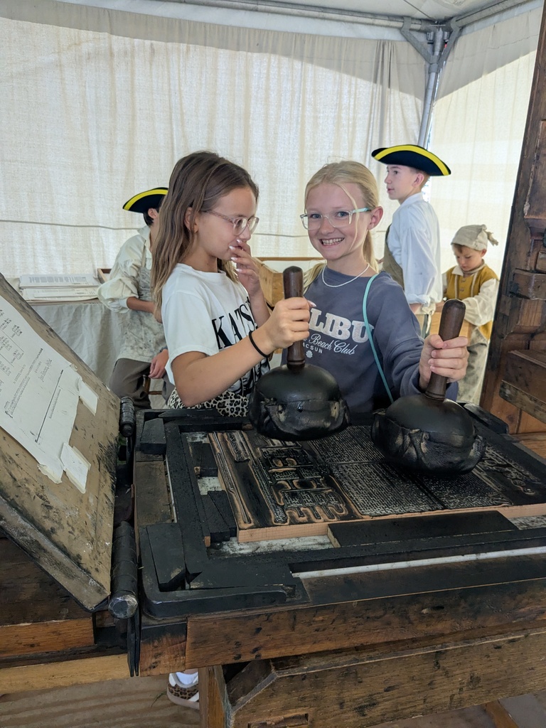2 students adding ink to a printing press.