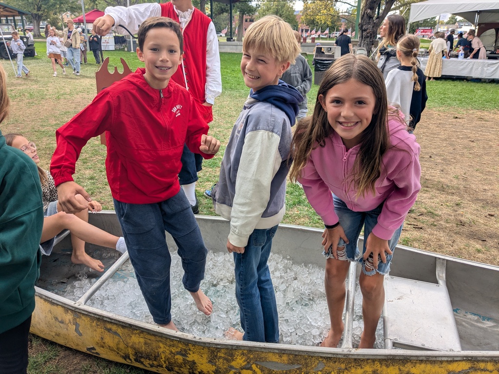 3 students standing in a boat full of ice.
