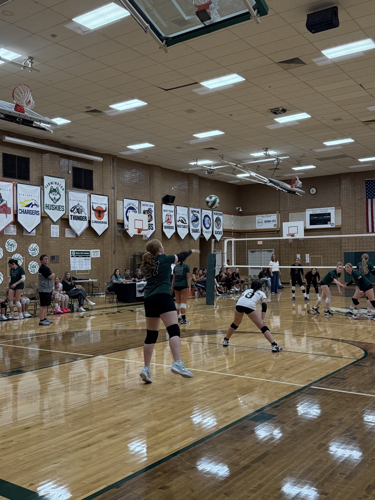 Student serving the volleyball. 