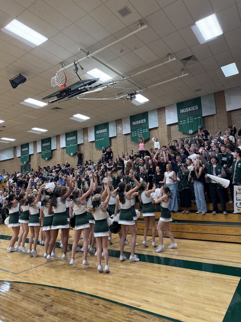 Fans cheering on the team with the cheerleaders. 