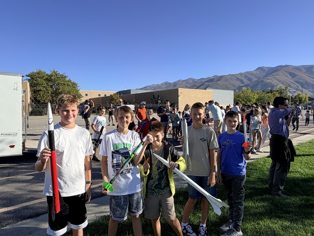 6th graders show off the rockets they built.