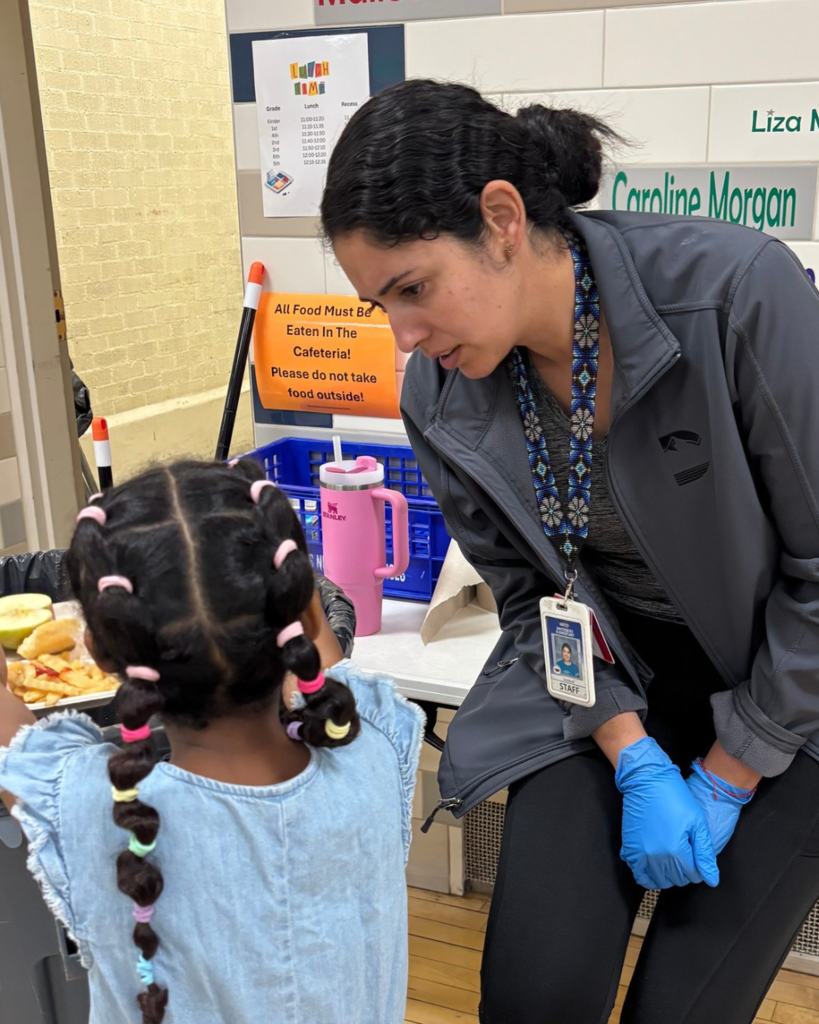 A custodian speaking with a student intently.