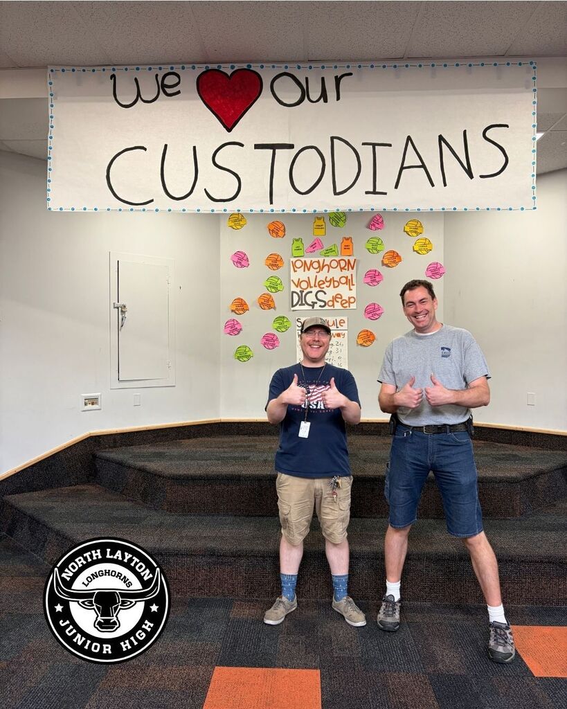 NLJH's Custodians standing in the commons in front of a sign that says "we heart our custodians"