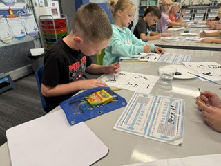 a boy writing Chinese characters on white paper