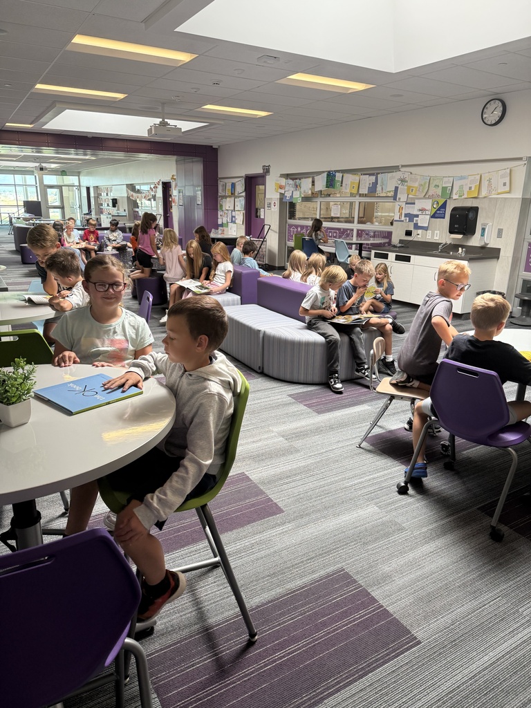 large group of students reading books inside a collaborative space