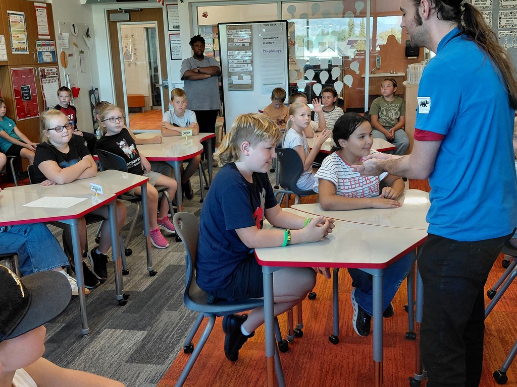 Students looking at a small animal in the hands of a aquarium specalist.