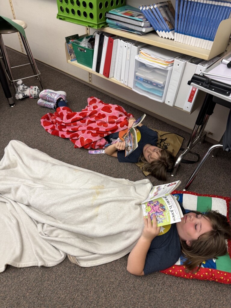 students laying in classroom reading a book