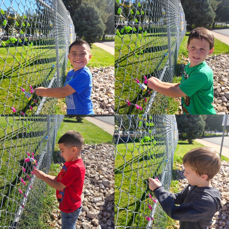 kindergarteners hanging their lock on the fence as a class