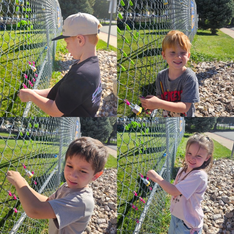 kindergarteners hanging their lock on the fence as a class