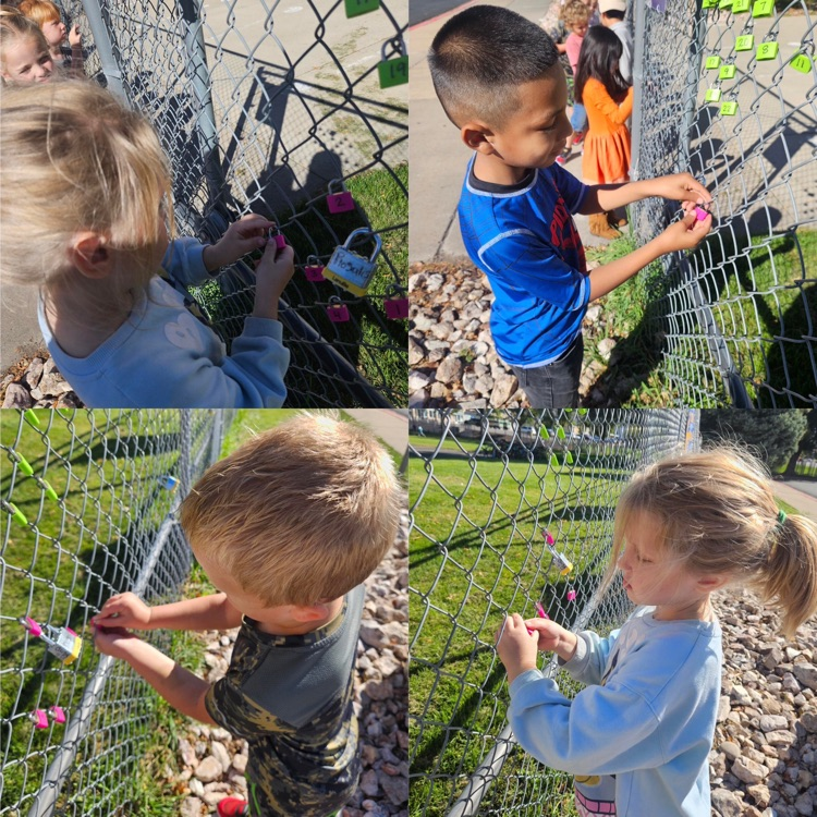 kindergarteners hanging their lock on the fence as a class
