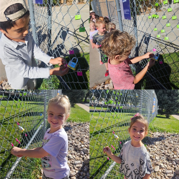 kindergarteners hanging their lock on the fence as a class