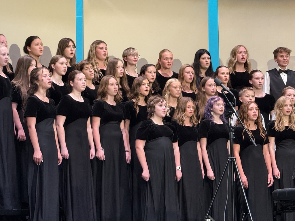 Female students singing wearing black dresses. 