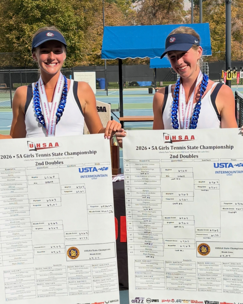 Woods Cross High School tennis players holding up their 2nd doubles state championship banners. 