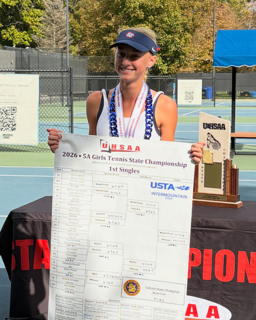 Woods Cross High School tennis player holding up her 1st singles state championship banner. 