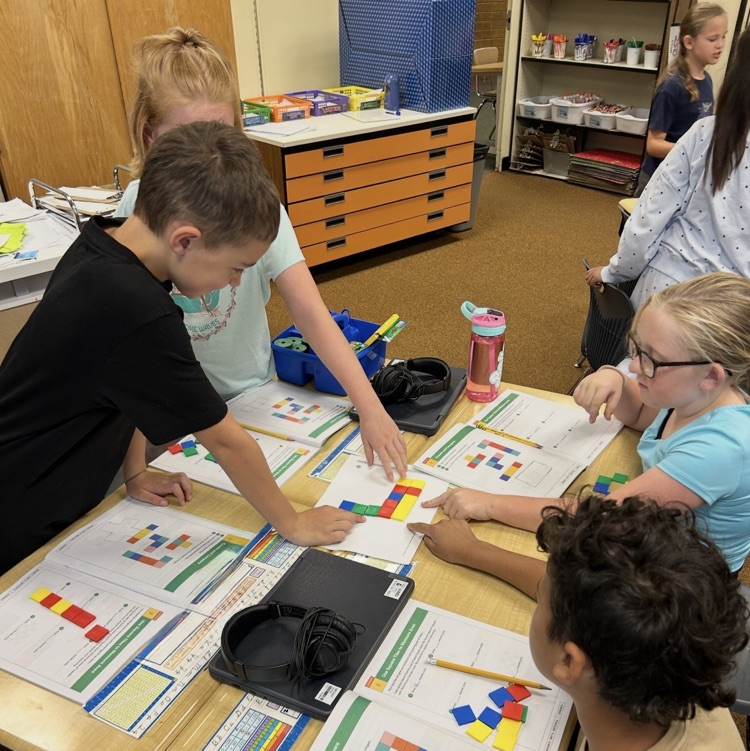 3rd graders working to learn about area using square tiles in math