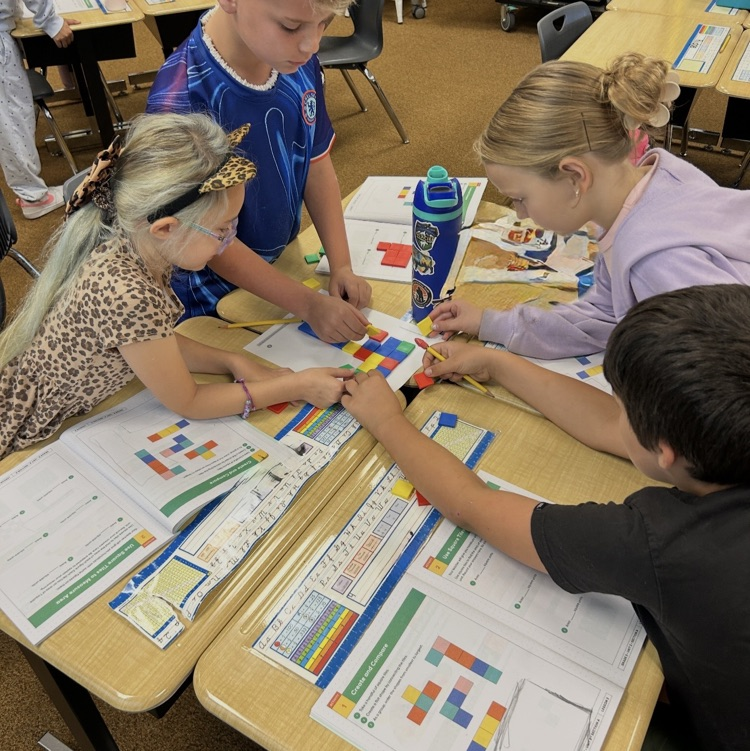 3rd graders working to learn about area using square tiles in math