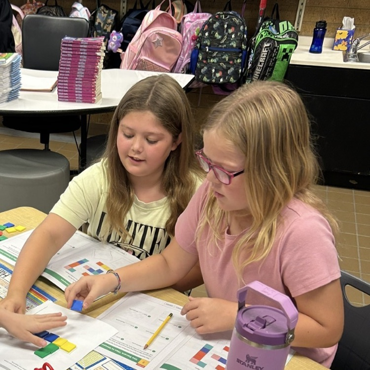 3rd graders working to learn about area using square tiles in math