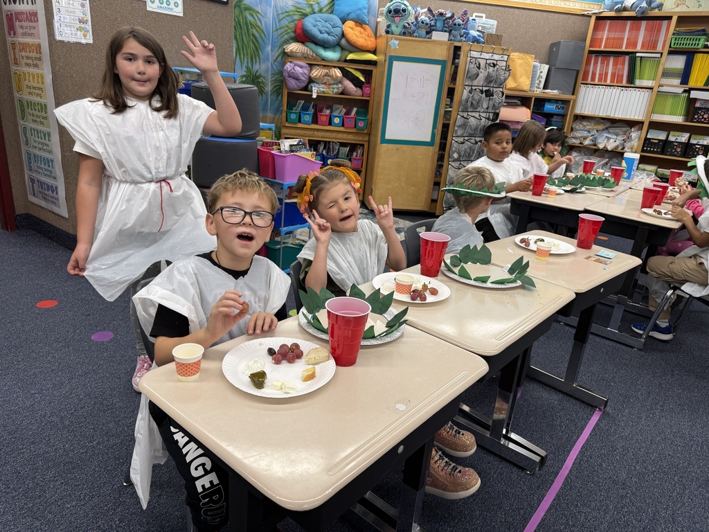 Students enjoy a celebration of learning about Ancient Greece by making “laurel” crowns and trashbag togas, eating dolmades (stuffed grape leaves), tzatziki, olives, cow and sheep feta cheese, bread with olive oil, grapes, and drinking grape juice.