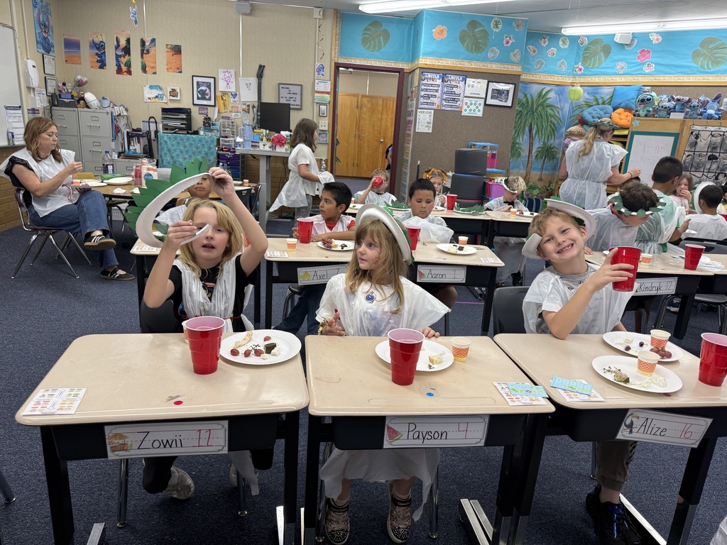 Students enjoy a celebration of learning about Ancient Greece by making “laurel” crowns and trashbag togas, eating dolmades (stuffed grape leaves), tzatziki, olives, cow and sheep feta cheese, bread with olive oil, grapes, and drinking grape juice.