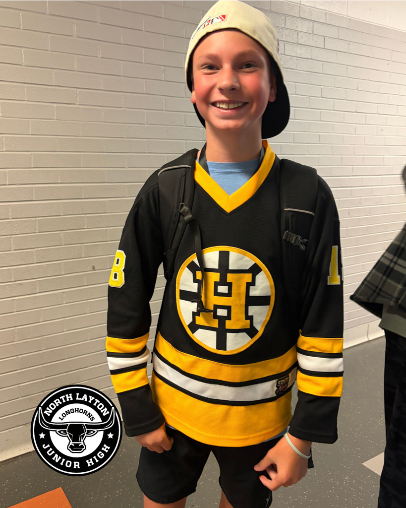 A student stands in the hallway in a hockey jersey dressed up like Adam Sandler