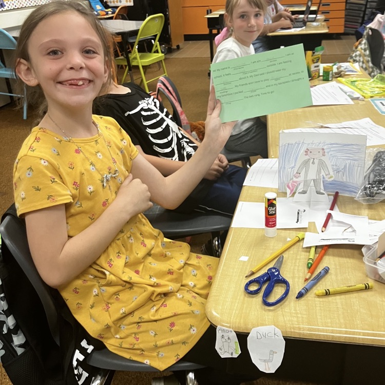 3rd grader displaying their creative and background they created during their specials BTS class