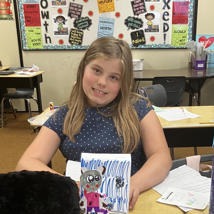 3rd grader displaying their creative and background they created during their specials BTS class
