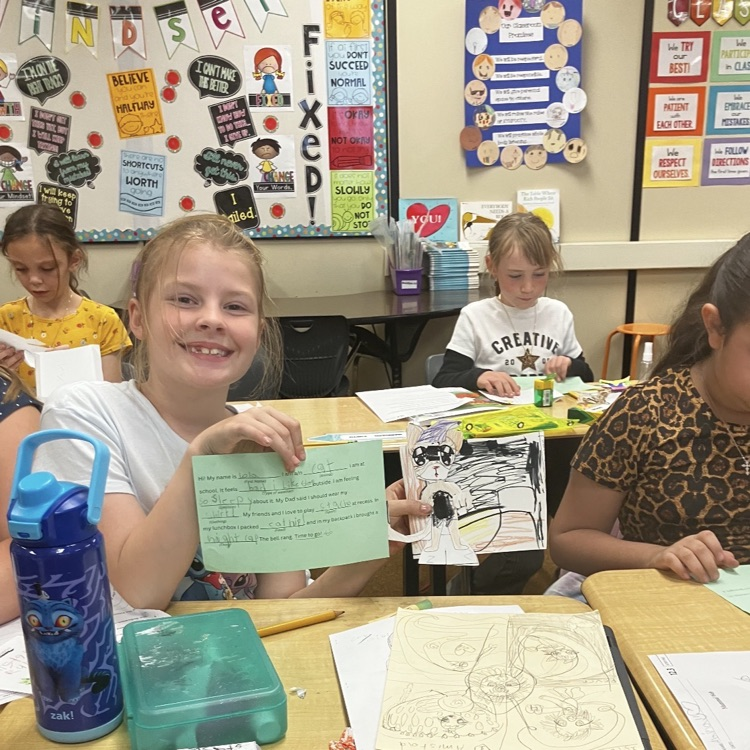 3rd grader displaying their creative and background they created during their specials BTS class