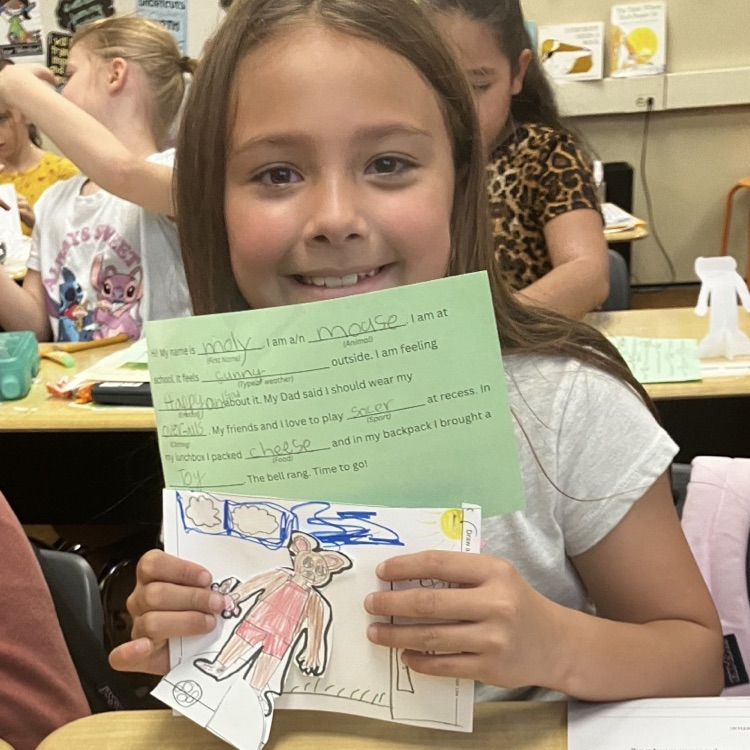3rd grader displaying their creative and background they created during their specials BTS class