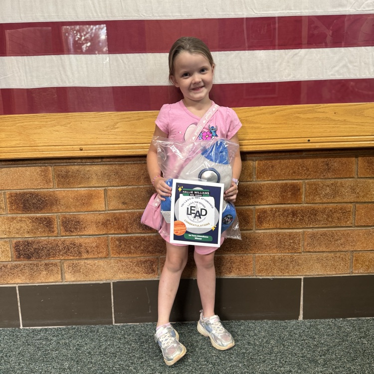 Student posing with attendance prize  