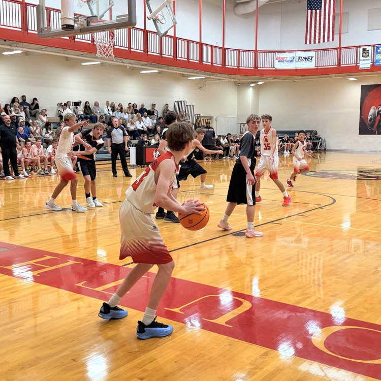 A South Davis basketball player prepares to make a play as defenders position themselves.