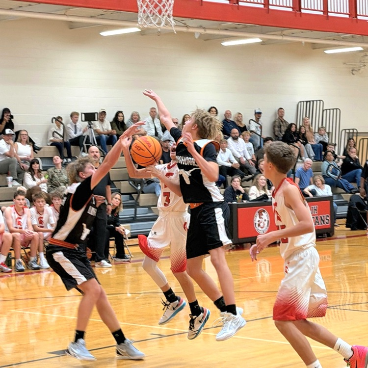South Davis and Longhorns basketball players battle for the ball during a game.