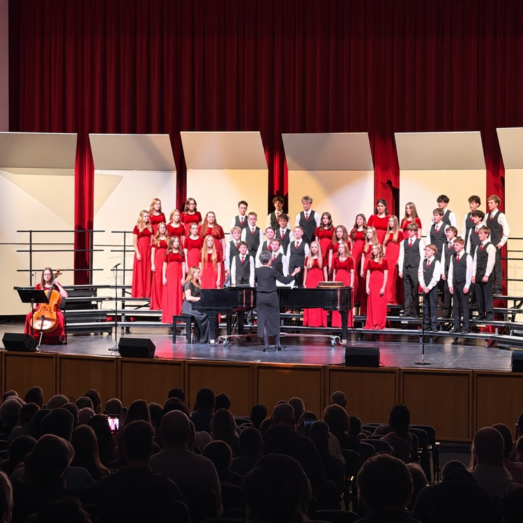 South Davis choir performs with piano and cello accompaniment in front of an audience.