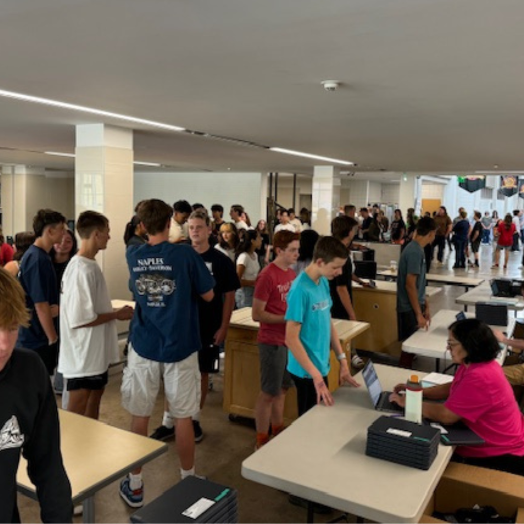 students lining up for computers at sophomore orientation