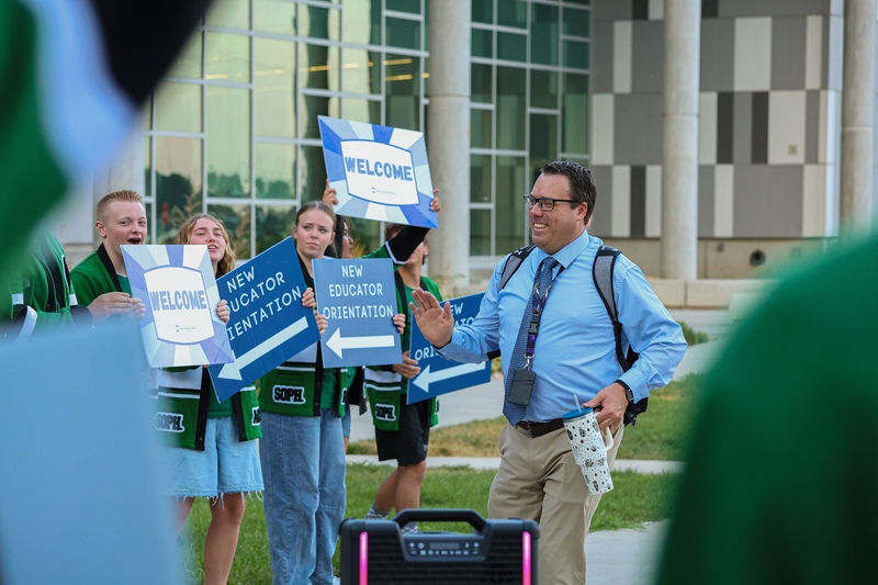 Teacher walking through a crowd of students.