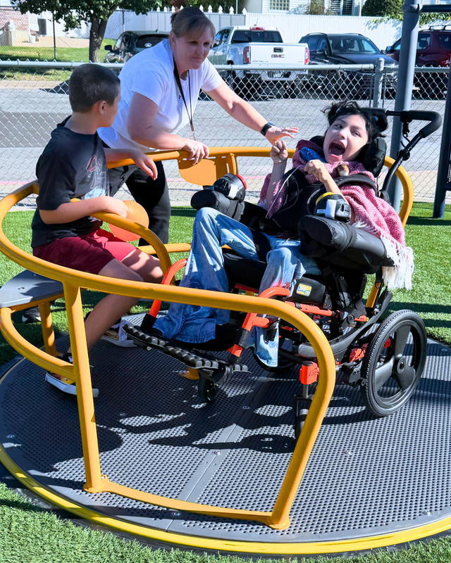 students play on playground equipment at their. new all abilities playground