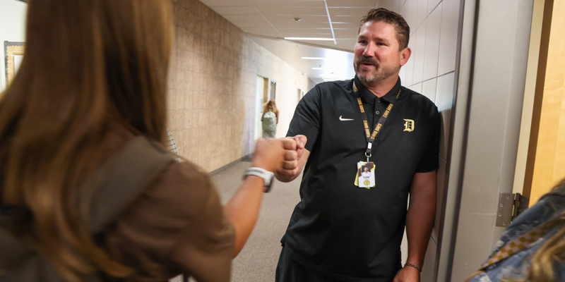 Roundy giving a knuckles to a student.
