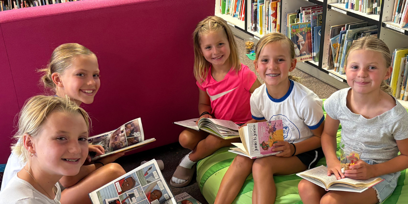 Five students reading on beanbags together.