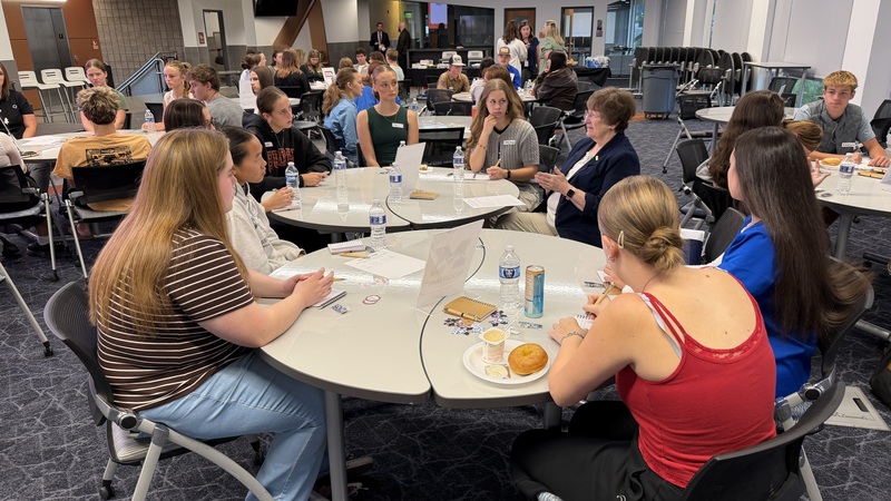 students discussing at tables with CTE coordinators