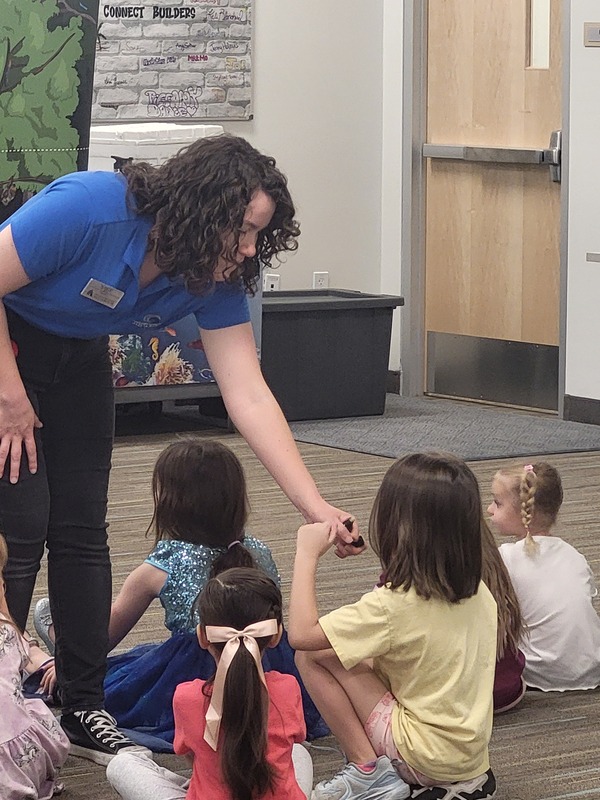 A student smells a rainforest-related item during the "Name the Smell" activity.