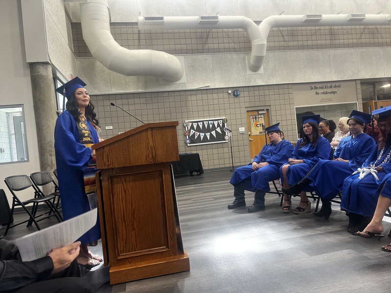 a femail student speaking from a podium in front of the audience