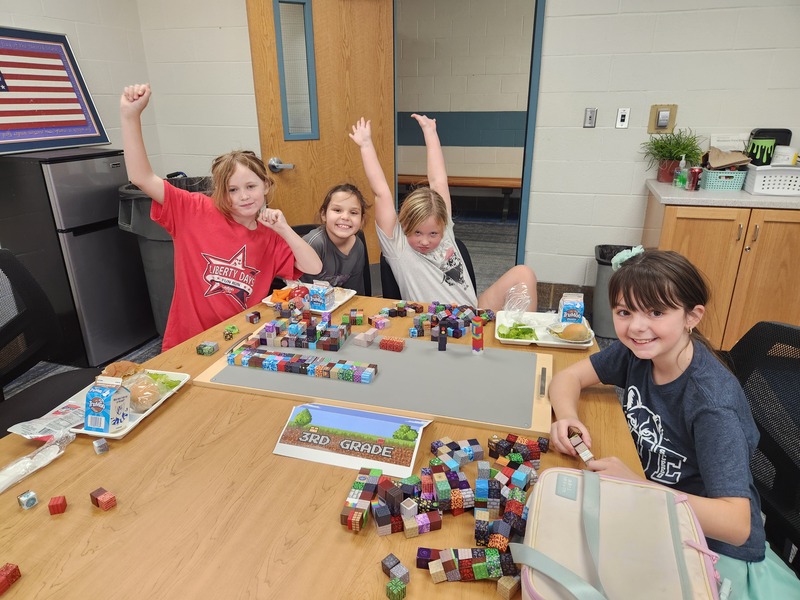 3rd graders eating lunch and building with minecraft blocks