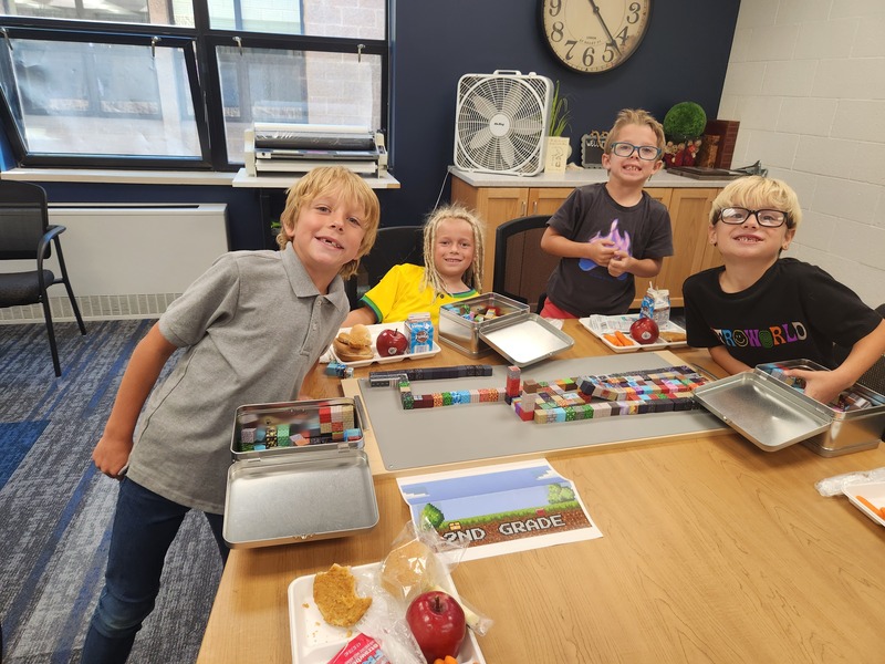 2nd graders eating lunch and building with minecraft blocks