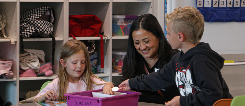 Students work on a project in class with an AASA member at Sunburst Elementary
