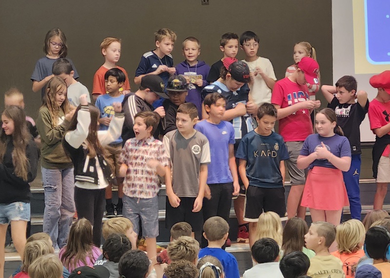 Students in the cafeteria watching peers receive brag tags
