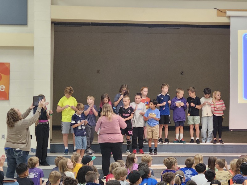 Students in the cafeteria watching peers receive brag tags