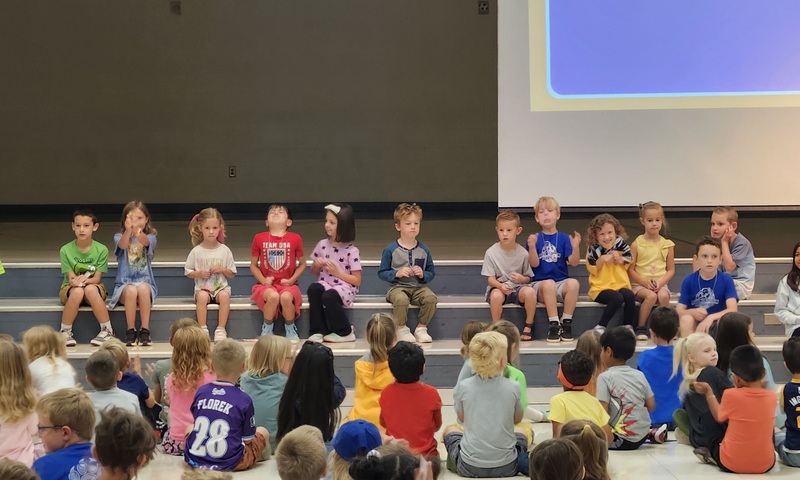Students in the cafeteria watching peers receive brag tags
